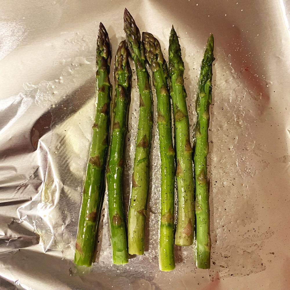 Asparagus, butter, salt and pepper on foil