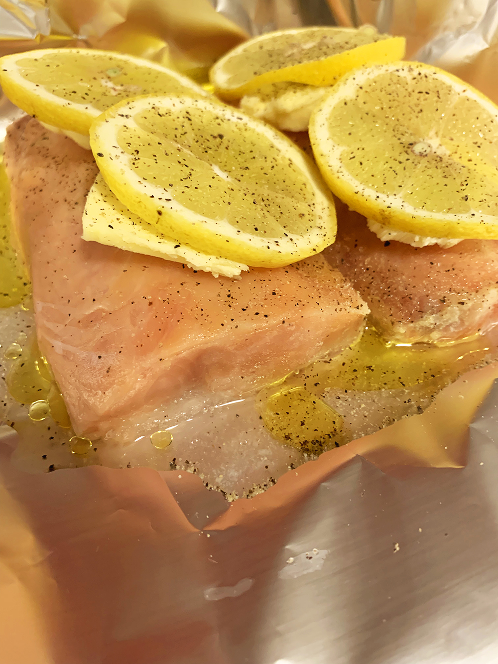 Salmon with butter, lemon, olive oil, salt and pepper in foil "pouch"